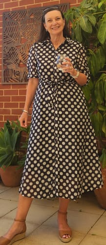 Reviewer standing outdoors wearing the Fallon Shirt Dress in navy and white polka dot, styled with tan wedges.