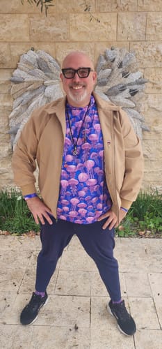 Customer standing outdoors wearing the vibrant Jellyfish Performance Hoodie under a tan jacket.