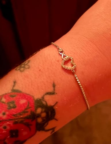 Close-up of a customer's Forever Love Bracelet on their wrist, showing the sparkling infinity heart.
