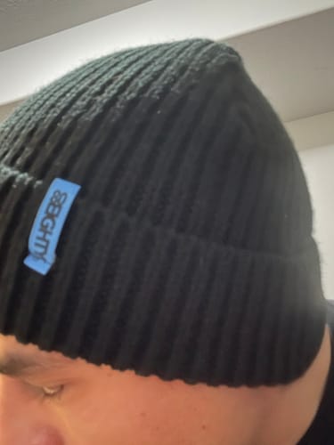 Close-up of a customer wearing the black, ribbed Onyx Beanie, showing the fit and texture.