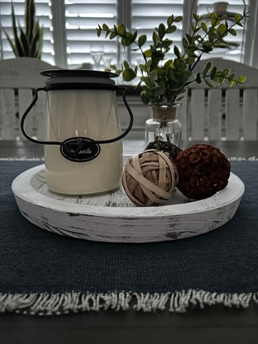 Customer's Very Vanilla Candle in its jar, displayed on a rustic white tray as home decor.