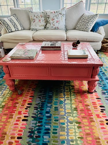 Customer's large coffee table painted with a glossy, coral LuxeLacquer in a living room.