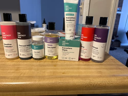 Customer's Post Workout Fresh Kit products, including body washes, oil, and deodorant, arranged on a wooden countertop.