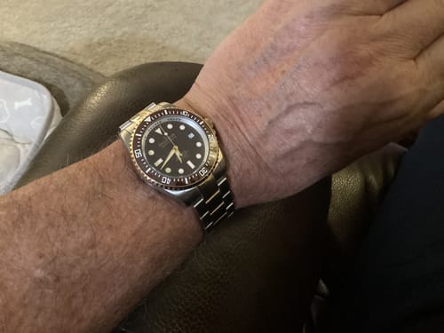 Customer wearing their Oceaneva Deep Marine Explorer II watch on their wrist, showing the brown bezel and two-tone band.