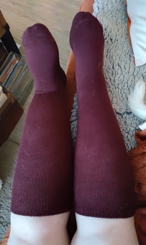 Recensent som bär de höga, vinröda Diasocks Komfortstrumporna.