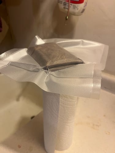 Close-up of the reviewer's Fontana Bison Trifold wallet being formed inside a clear vacuum seal bag.