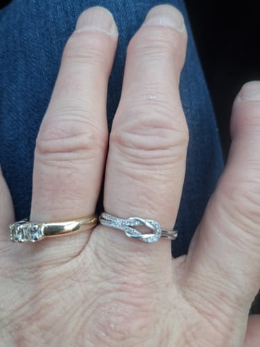 Reviewer's hand wearing the sparkling silver Love Knot Ring on a finger.