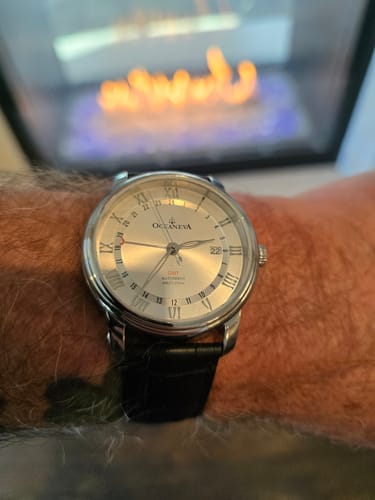 Customer's silver Oceaneva OceanTrek GMT Automatic Watch with a black leather strap shown on their wrist.