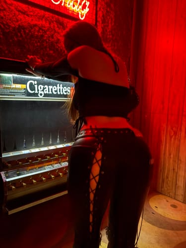 Reviewer from behind wearing the black Vice Pants, showing the side lace-up detail in a room with red light.