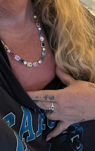 Close-up of a reviewer wearing their colorful Moissanite Cross & Gemstones Chain.