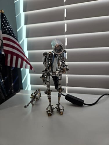 Customer's assembled metallic Terminator M model standing on a desk next to an American flag.