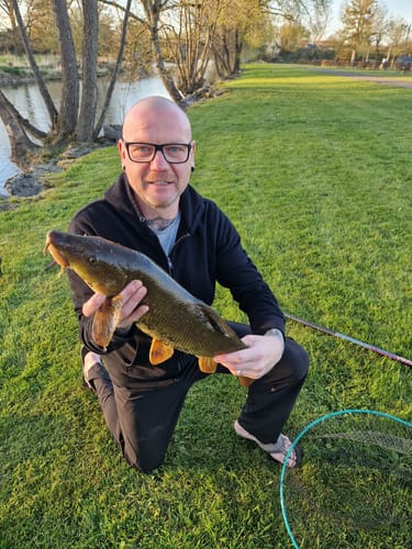 Recensent toont een grote barbeel gevangen met de Premium Select vispellets aan de waterkant.