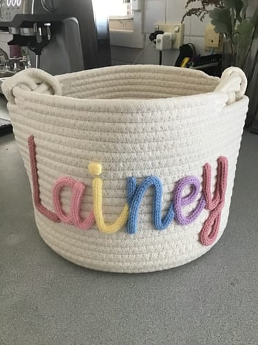 Customer's personalized off-white knitted basket with the name 'Lainey' in multicolor yarn.