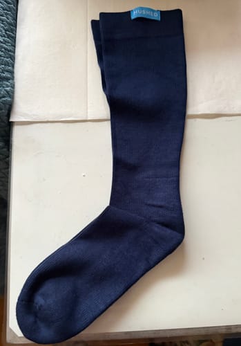 Customer's pair of dark blue compression socks laid out flat, showing the brand tag at the top cuff.