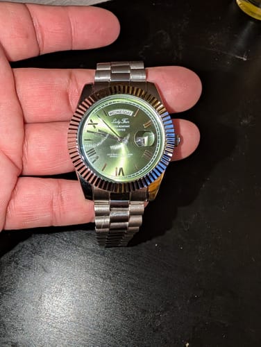 Customer holding their Lucky Fours® Santos watch, showing the green dial and silver-tone band.