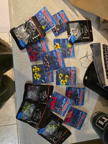 Customer's large order of MirrOlure Pro Series Screw Lock Jigheads in assorted colorful packages on a counter.