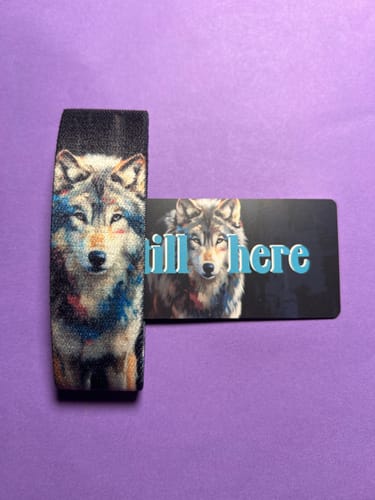 Customer's Still Here Bracelet with a colorful wolf design, shown with its matching card on a purple background.