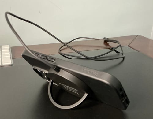 Customer's SPOTMINDERS wireless charger used as a stand for a black iPhone, showing the top power cord.