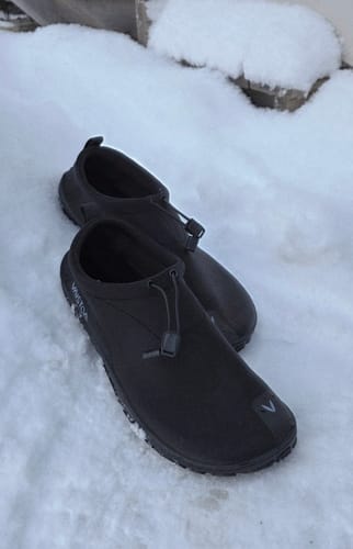 Arvostelijan Vaistoa Vire -avantopaljasjalkakengät aseteltuna lumeen.