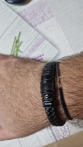 Customer's close-up of the black bracelet with its detailed braided band worn on a wrist.