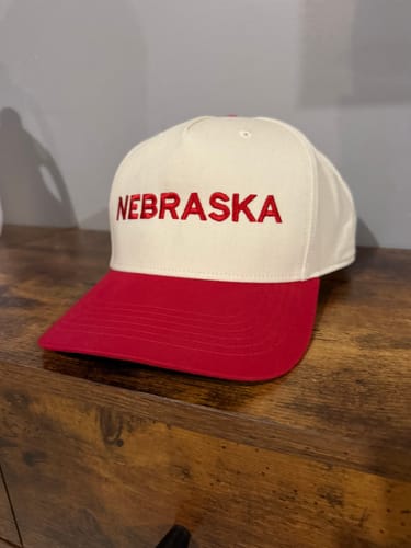 Reviewer's custom embroidered 'NEBRASKA' hat in red and white, shown from a different angle.