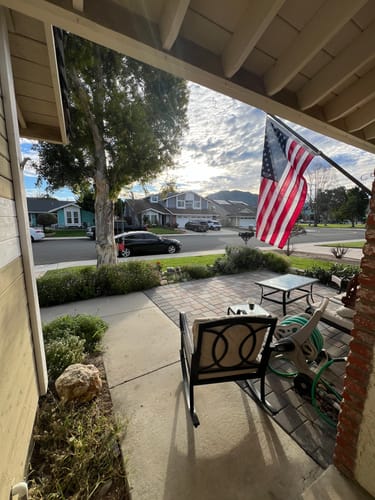 Customer's Prestige House Flag Pole kit mounted on their porch, displaying the included American flag.