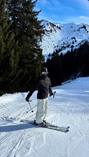 Customer wearing baggy snow pants while skiing on a snowy mountain slope.