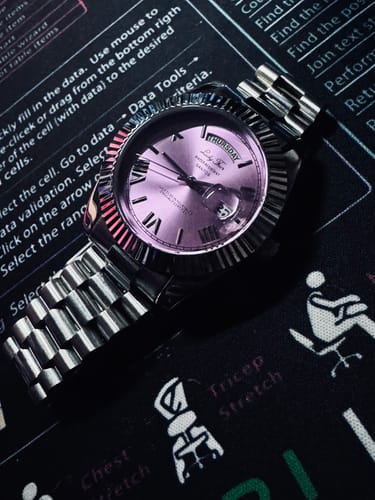 Customer's Lucky Fours® Santos watch with a purple dial and a silver-toned metal band, shown on a desk mat.