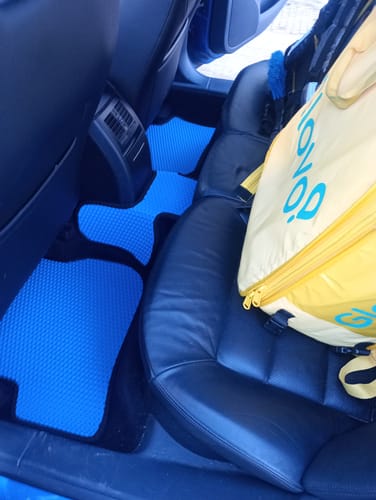 Zdjęcie klienta przedstawiające dopasowane, niebieskie dywaniki samochodowe zainstalowane na tylnej podłodze samochodu.