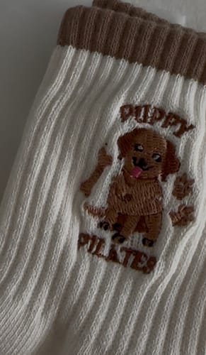 Customer's close-up of the white ribbed Puppy Pilates socks, showing the brown embroidered puppy design.