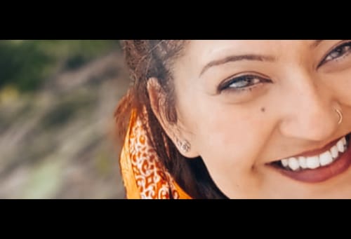 Close-up of a reviewer smiling while wearing the natural Meli contact lenses.