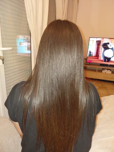 Cliente de dos montrant le résultat sur ses cheveux longs et lisses après avoir utilisé la Gamme Amla Tanino.