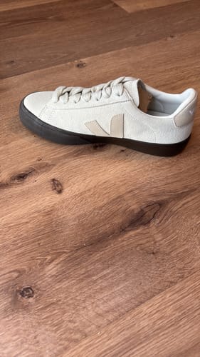 סניקרס זמש מדגם Veja Campo Bold של לקוח/ה, בצבע בז' עם סוליה שחורה, על רצפת עץ.