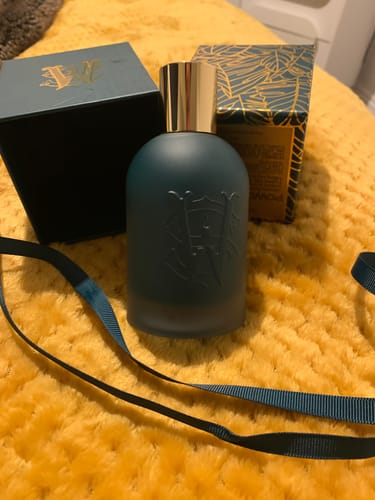 Reviewer's Powder Ballad perfume in a matte teal bottle with a gold cap, shown with its matching packaging.