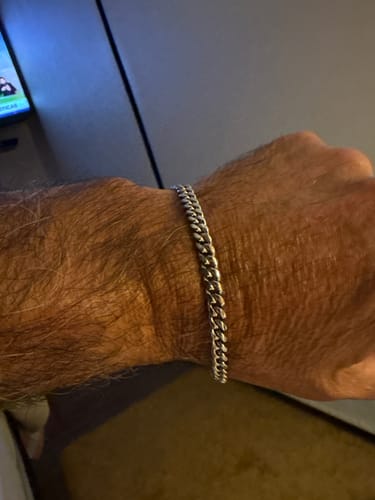 Un cliente mostrando su Pulsera Miami Cuban de 5mm plateada y brillante en la muñeca.