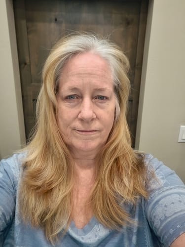 Reviewer's hair before using the Instant Dye Shampoo, showing long blonde hair with prominent gray roots.