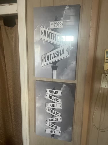 Customer's two personalized 'COUPLES DATE OF LOVE' canvases in a black-and-white street sign style, hung on a wall.