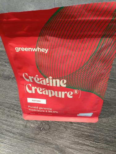 Sachet rouge de Créatine Creapure® d'un client, posé sur une table en bois.