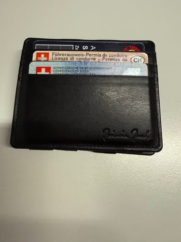 Customer's black Flap Boy Slim wallet holding several cards in its external slots.