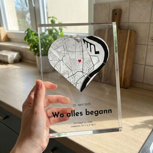 Ein Kunde hält den personalisierten Acrylblock 'Unser Ereignis' in der Hand. Der massive Block zeigt eine herzförmige Karte und Text.