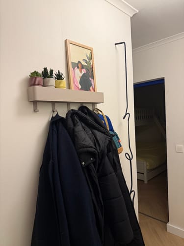 Klant toont de Spinder Design Dax Play 5 wandkapstok in een hal, beladen met meerdere zware jassen.