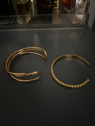 Customer's review photo showing two gold bracelets from the December Bundle: a multi-band cuff and a beaded cuff bracelet.