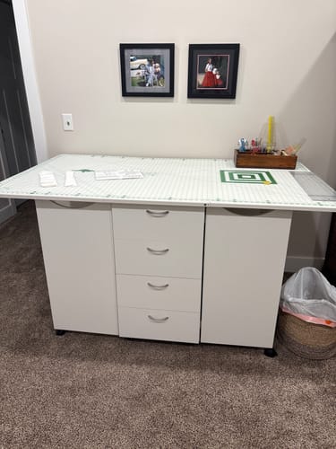 Reviewer's white Kookaburra Cutting Table shown fully extended in a craft room, highlighting its spacious drawers and top.