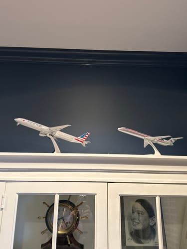 Reviewer's assembled American Airlines MD-80 model displayed on a cabinet next to another airplane model.