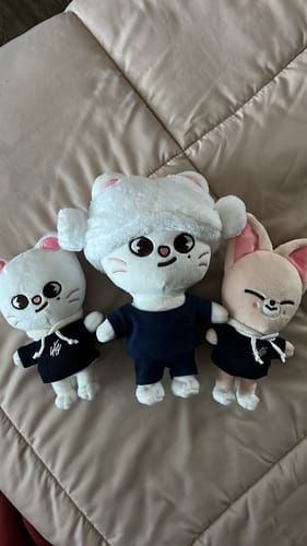 Customer's three SKZOO plush toys, including the Jiniret version, sitting together on a quilted comforter.