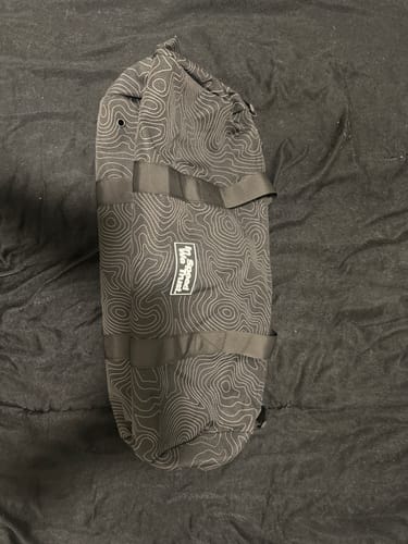 Customer's black 'Pathway' Cash Duffle Bag with a white topographic pattern laid flat on a dark surface.