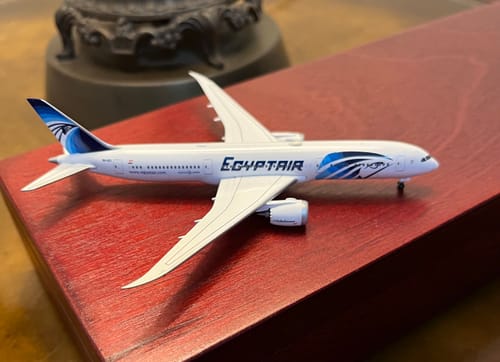 Customer's HERPA EGYPTAIR 787-9 model airplane resting on a red wooden surface.