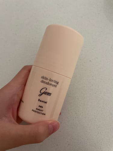 Customer holding the light pink Skin-Loving Deodorant Roll-on in their hand.