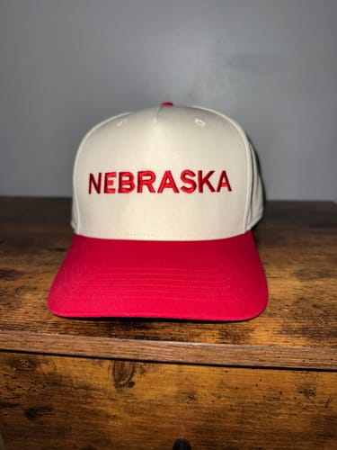 Customer's custom embroidered hat in red and white with 'NEBRASKA' stitched on the front.