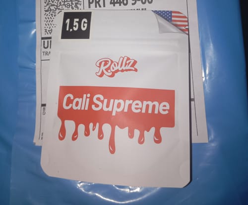 Customer's white and red pouch of CALI SUPREME THCA Flower on a shipping package.